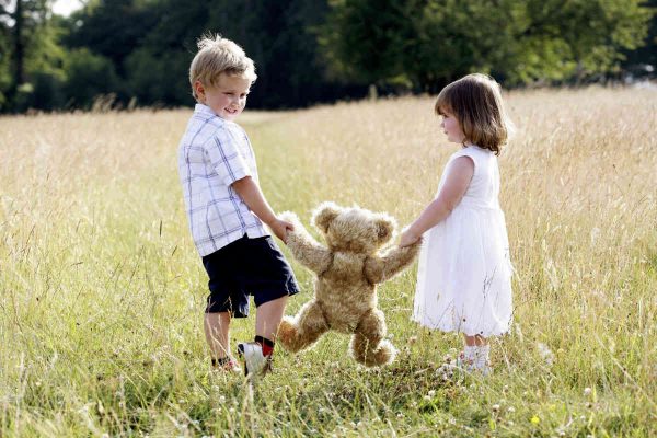 dječak i djevojčica igraju se s medvjedićem